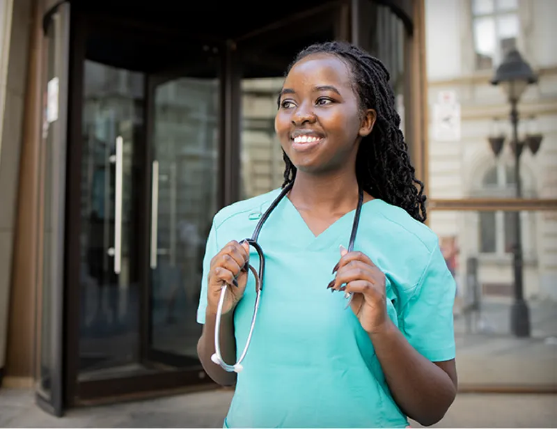 A nurse standing outside a building