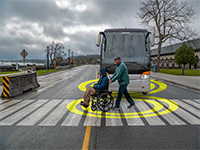 A man in a wheelchair interacting with a bus