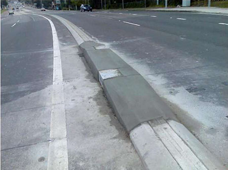 This is a photograph of infrared detectors installed into newly poured concrete in the median of a road.
