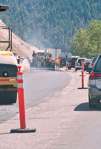 This is a photograph of road construction taking place on a mountain road. Please see the Extended Text Description below.