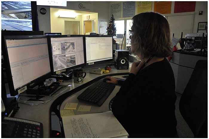 Photo showing a single example traffic management center workstation with an operator at a desk with several computer screens.