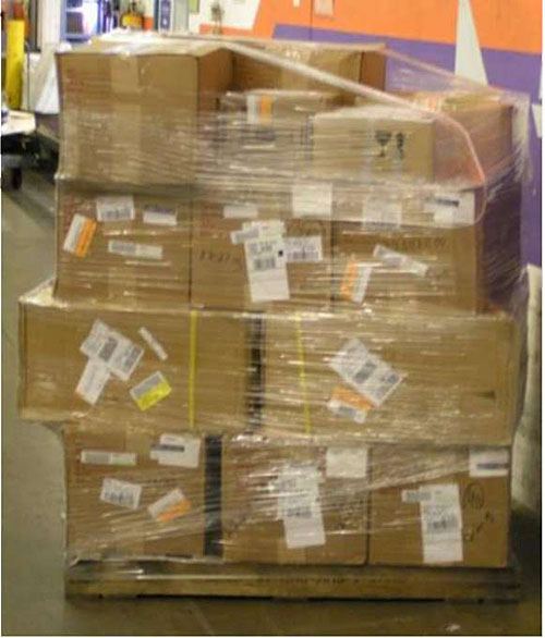 This is a photo taken in the Vancouver airport freight facility. In this photo, there is a pallet of large cardboard boxes that are shrink wrapped into a bundle.
