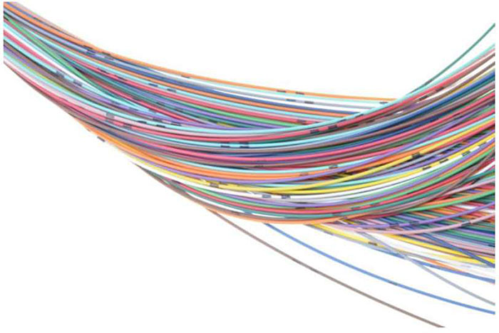 Stock photo of a large number of computer network wires hanging from the left to the right side.