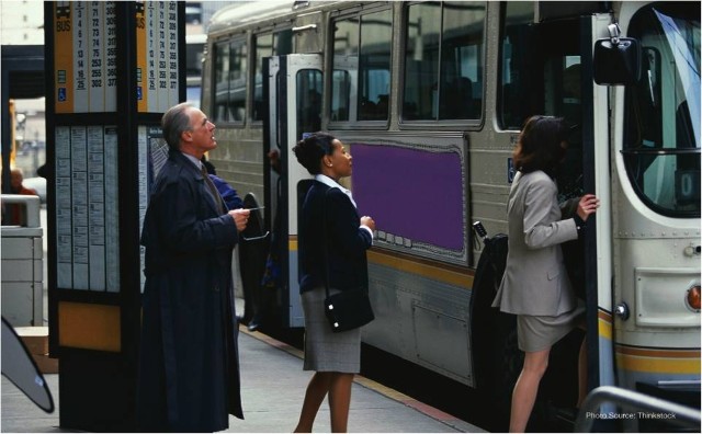 photograph of three people boarding a bus