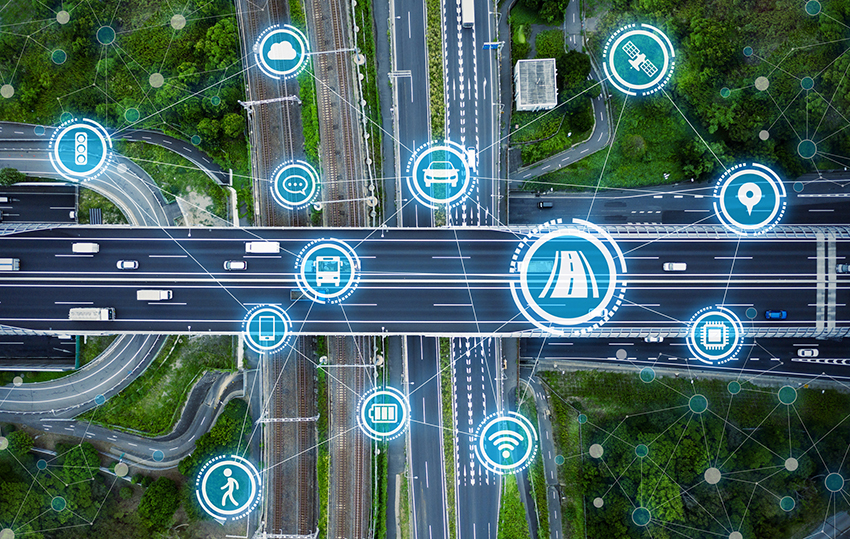 various ITS-related icons superimposed on an overhead photo of a highway interchange: a road, a satellite, a cloud, a traffic light, a bus, a pedestrian, a car, a road, etc.